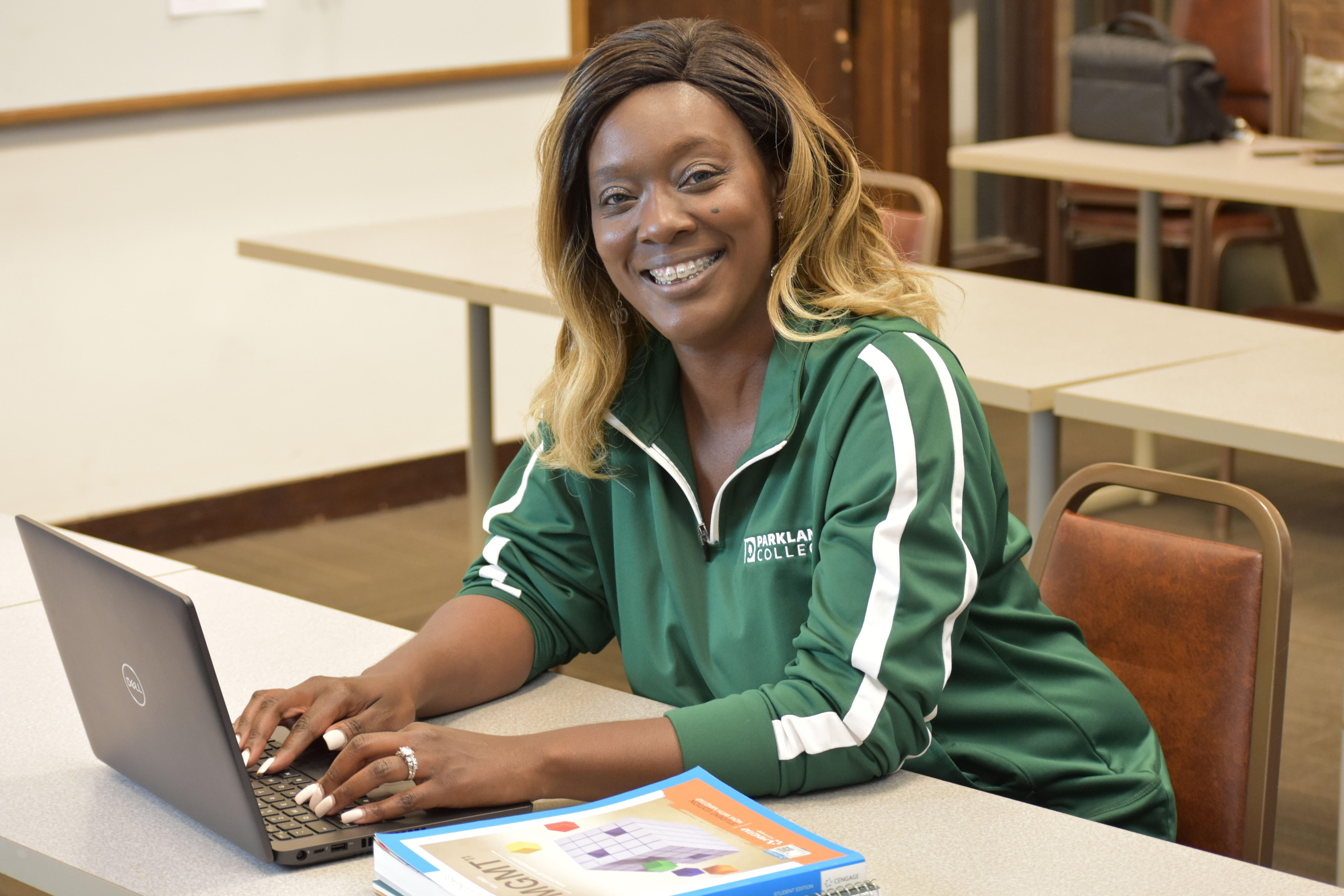 smiling african american woman typing on laptop